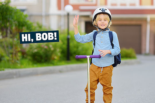 Foto: Ein kleiner Junge winkt Richtung Kamera. Text: „Hi, Bob!“